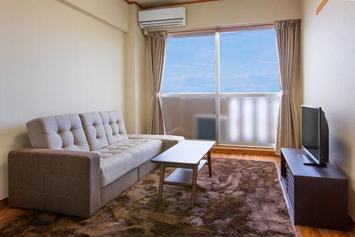 Living room with sofa and balcony with sea view